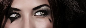 A young woman’s eyes with a Halloween themed make-up and wearing cosmetic contact lenses.