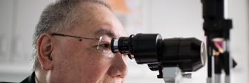 Professor Peng Khaw  looking into a microscope