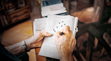 Hands of a person completing a crossword