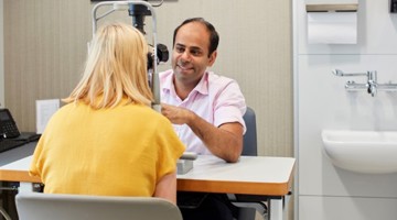 Romil Patel undertaking an eye examination with a patient