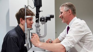 Professor Paul Foster examines a patient