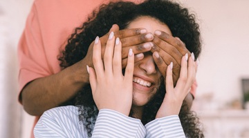 Somebody covering a woman's eyes from behind